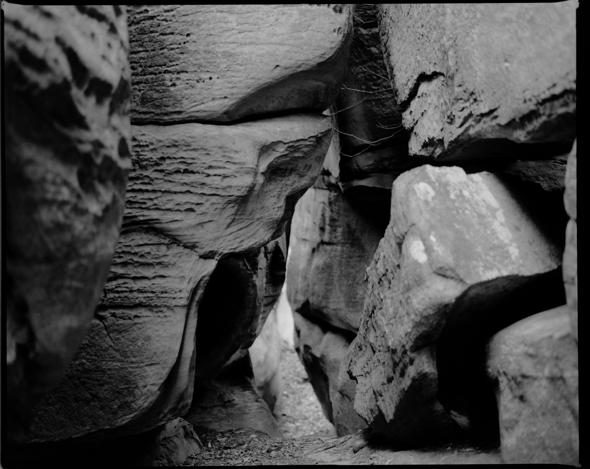 Black and white close-up of weathered rock formations — textured surfaces and deep crevices creating an abstract composition - this is a shot of eroded crevices and sandstone boulders in The Channels Natural Area Preserve.